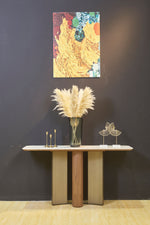 ELISE walnut veneer and brushed bronze console table styled against a dark wall – front view
