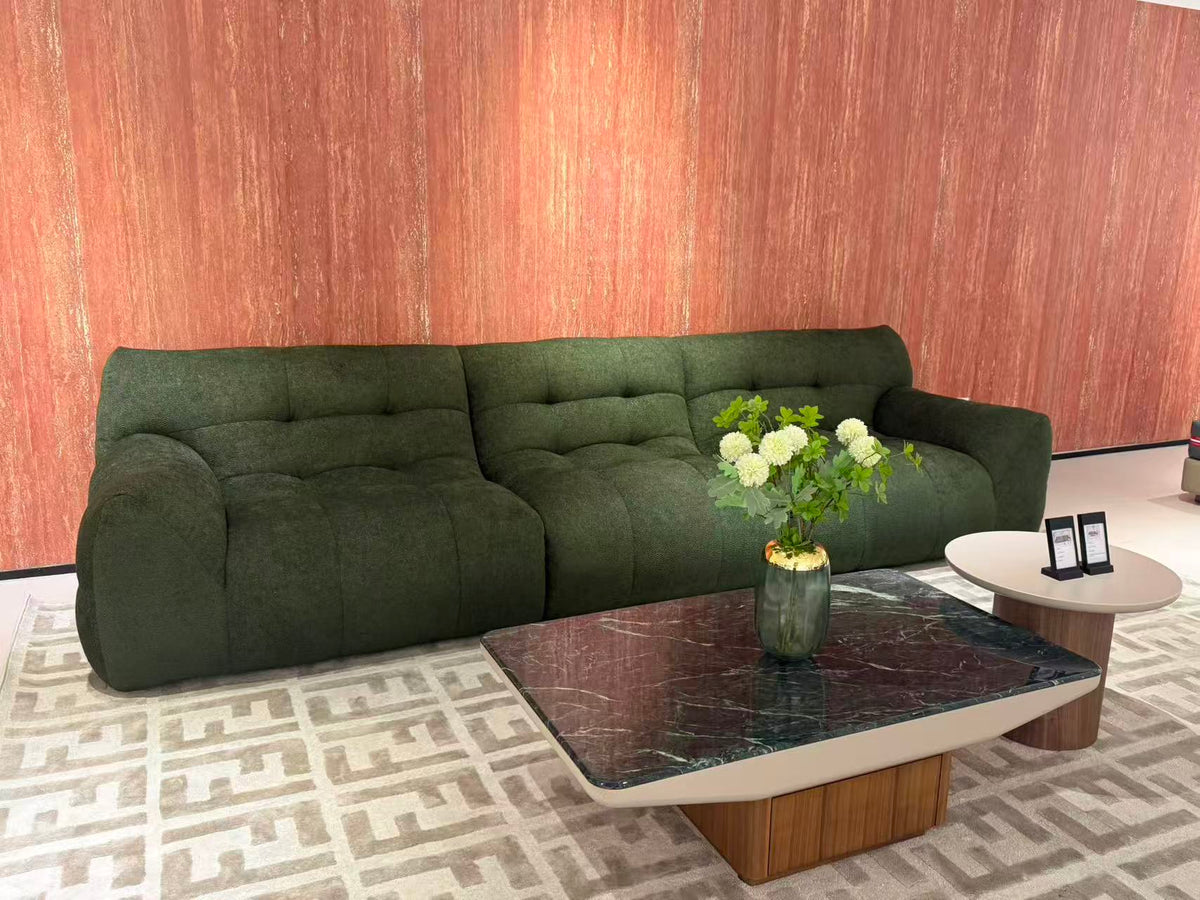 OLIVA dark green sculptural sofa with rounded armrests and deep cushioned seating.