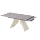 Modern beige extension dining table showing rotating grey sintered stone extension leaf partially opened